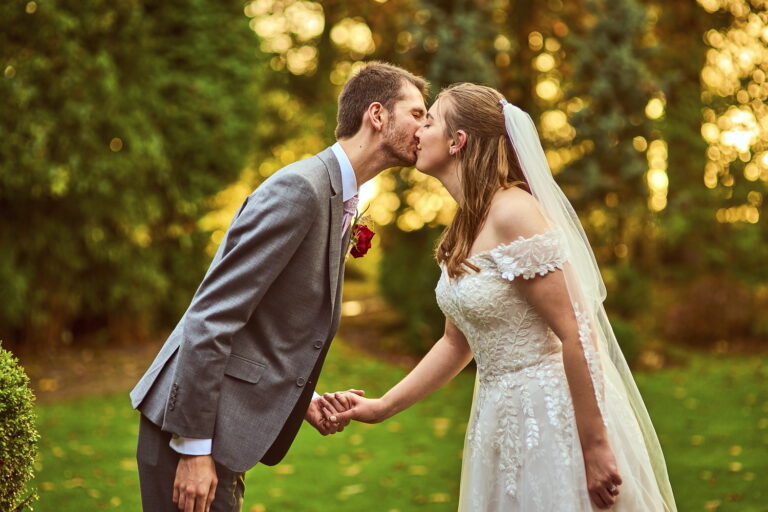 Newlywed couple sharing a romantic kiss on their wedding day captured by Keylight Photography.