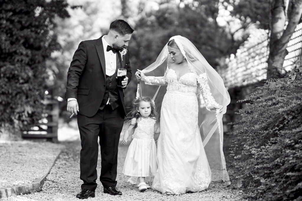 cute moment when the bride and groom walking with with little bridemaid on wedding day
