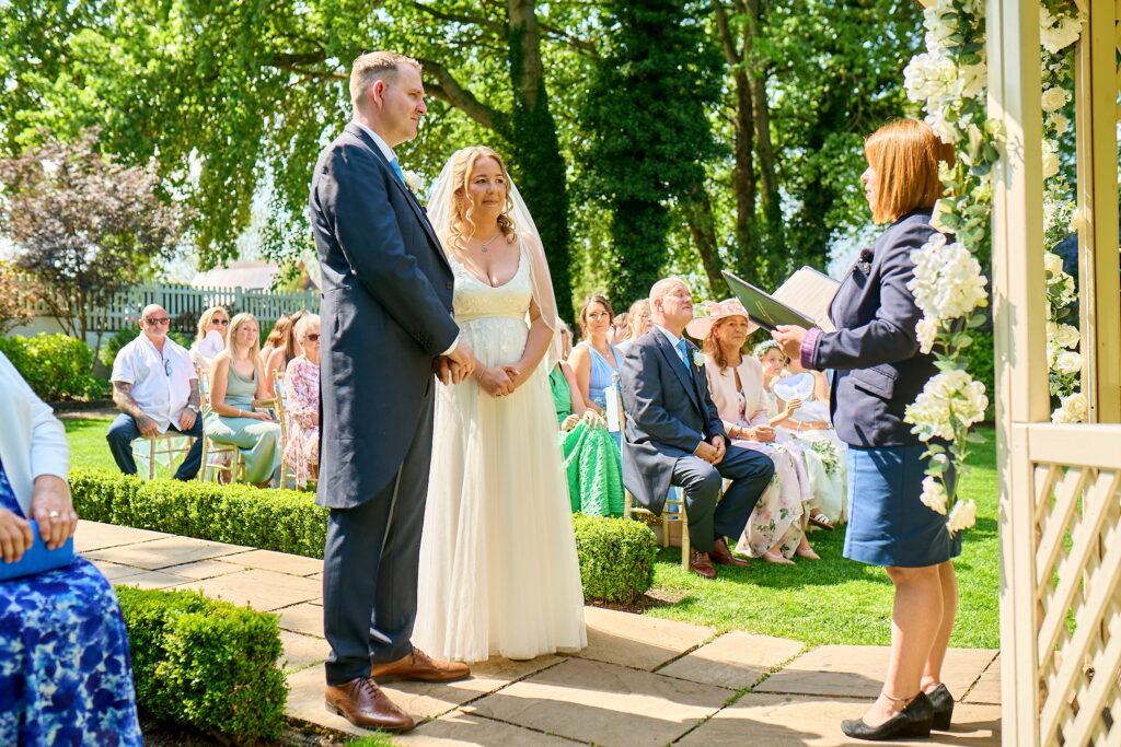 The bride and groom looking at each other and saying yes during their wedding ceremony.