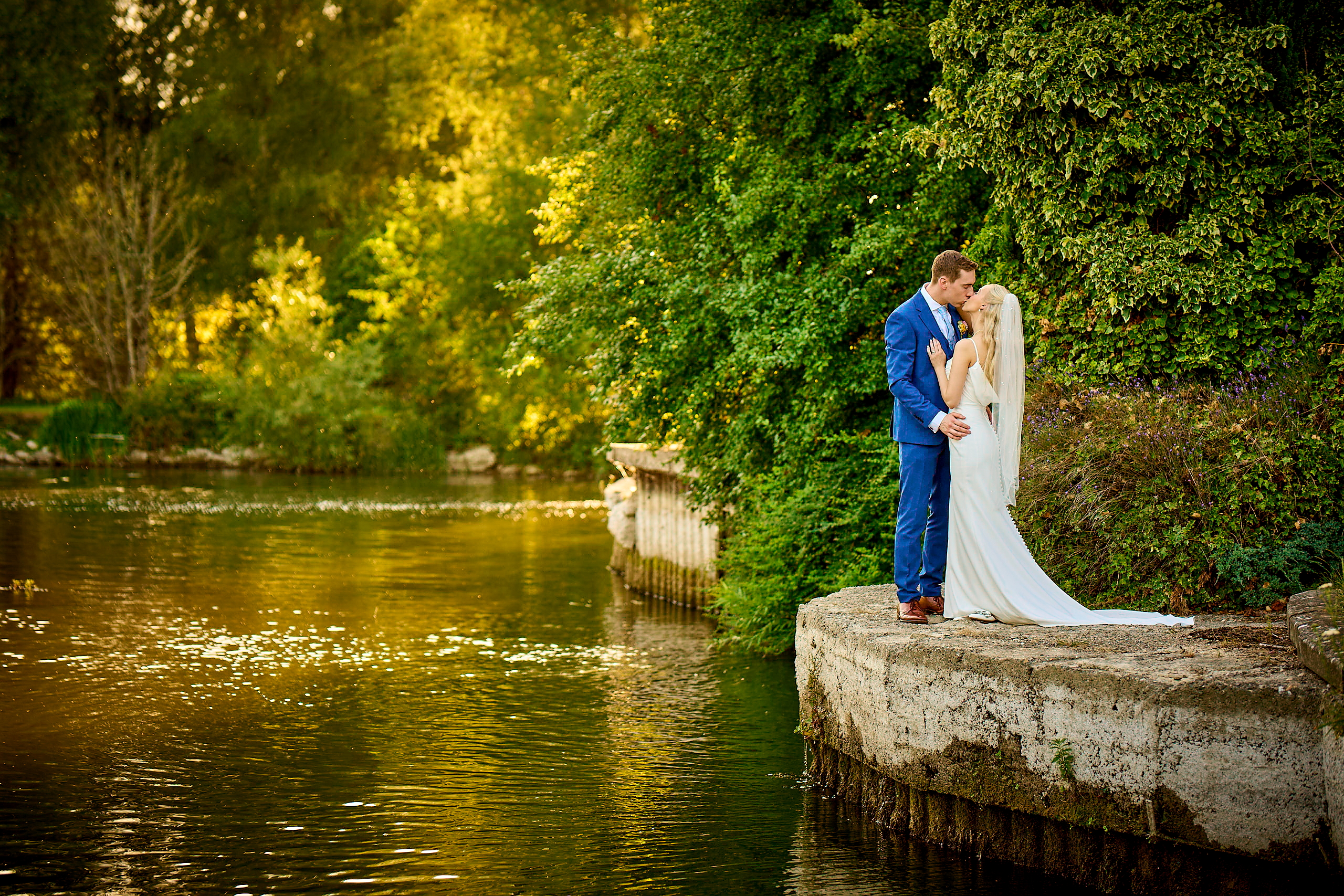 A newlywed bride and groom kissing outside their Coventry wedding venue.