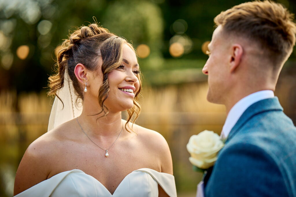 A classic wedding photography portrait of a newlywed bride and groom smiling together.