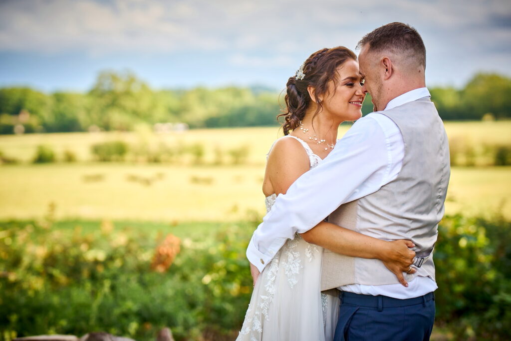 Beautiful Warwickshire wedding photography showing the bride and groom walking through the venue gardens.